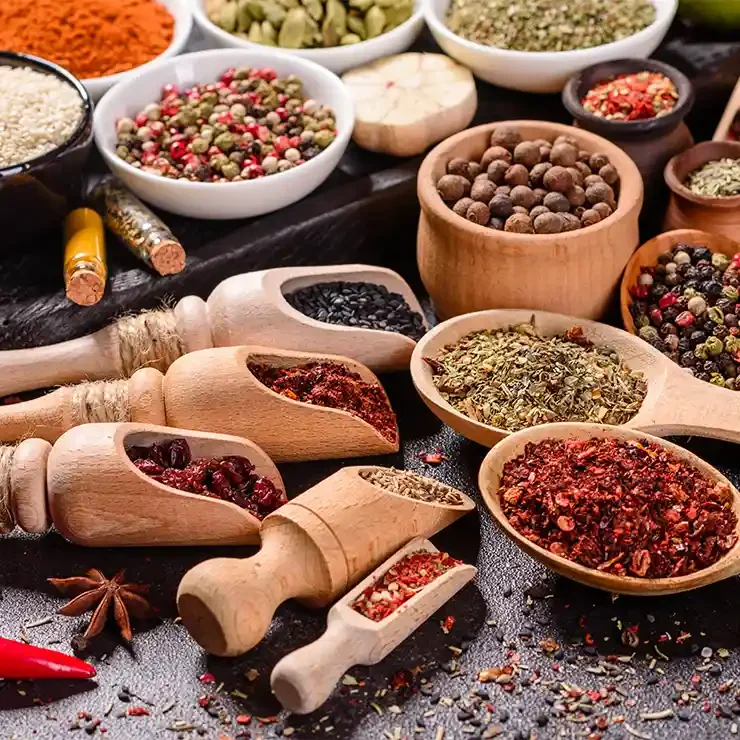 A collection of colorful spice jars filled with various spices like turmeric, cumin, and chili flakes.